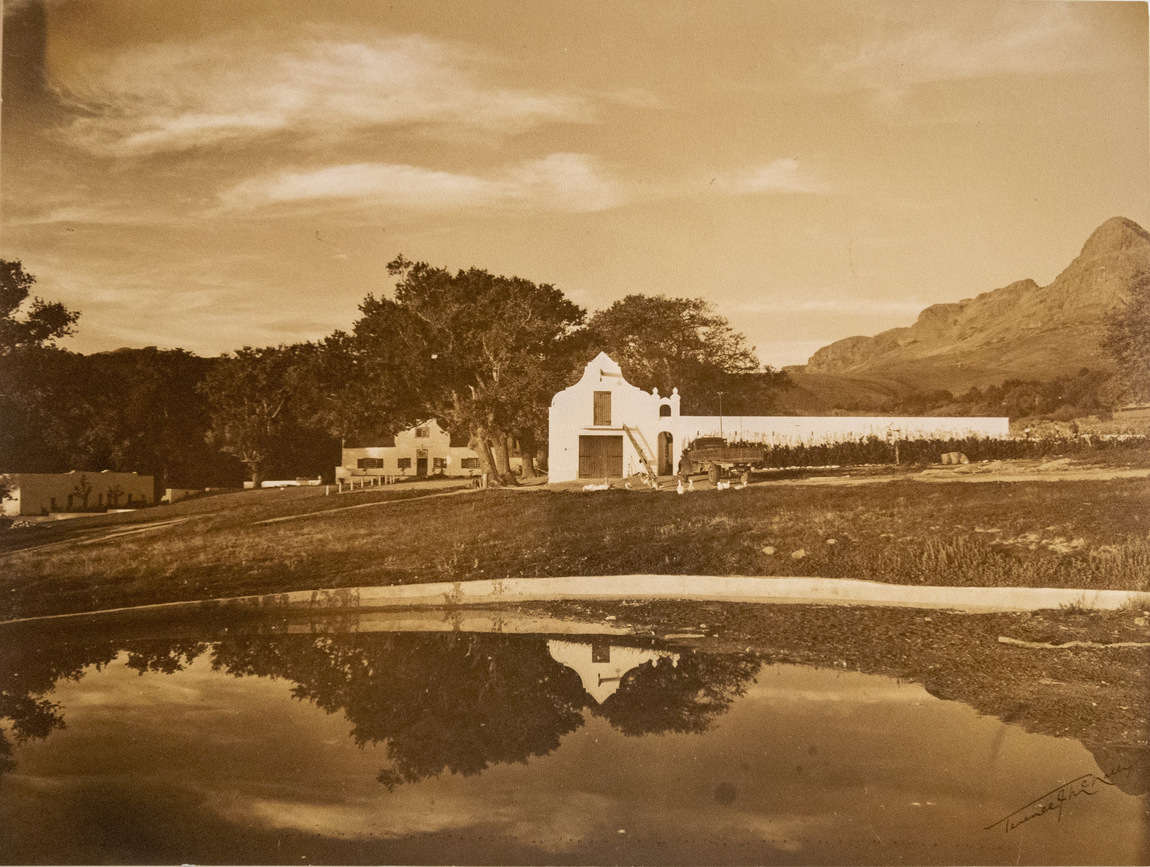 Vintage sepia photograph of Navarre estate with lake reflection and mountain