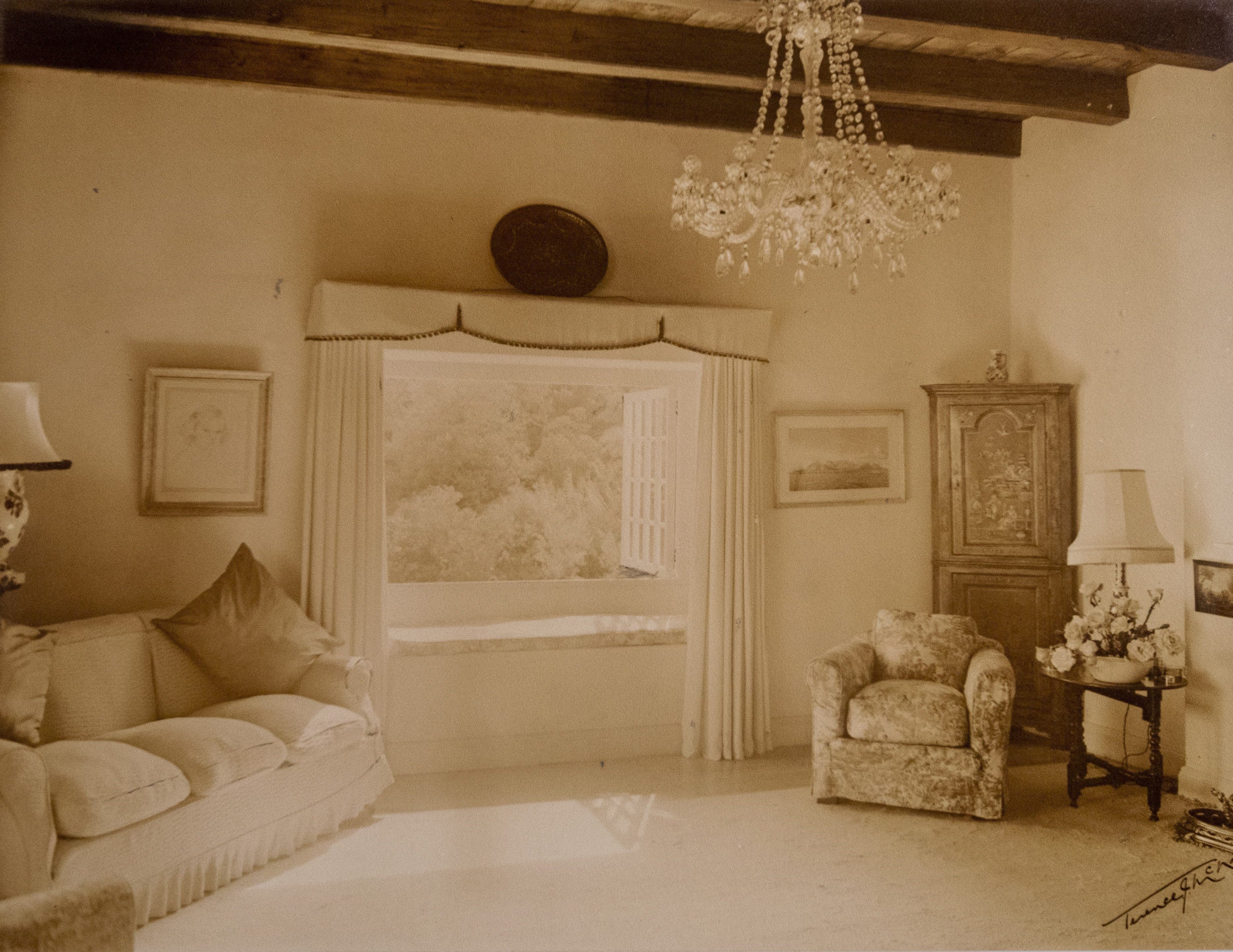 Vintage sepia interior with chandelier, sofa, and wooden beams