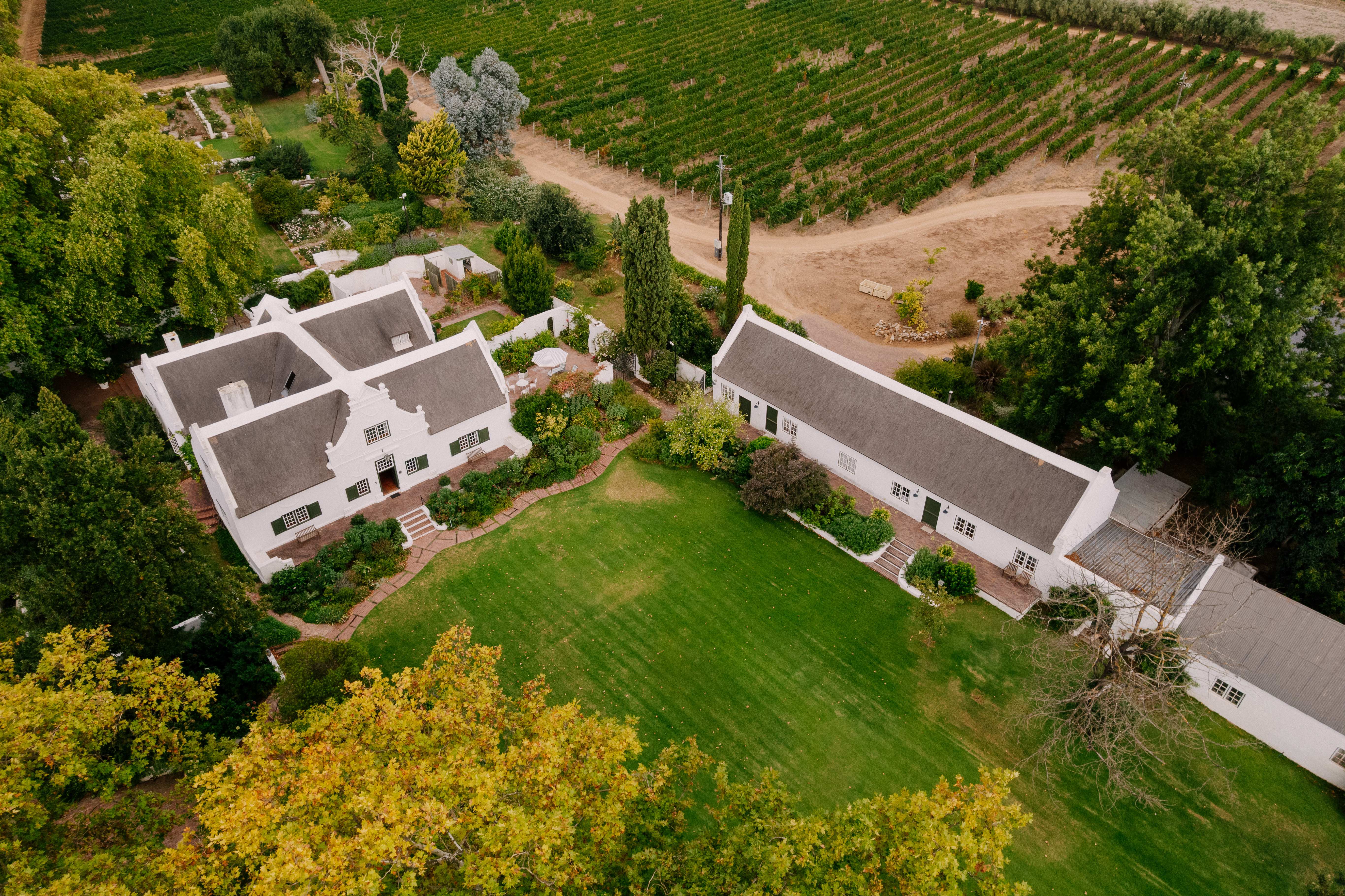 Aerial view of Navarre Residence showing Cape Dutch manor house, cottage, manicured lawns, and vineyards